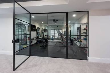 Black-framed glass partition wall with pivot door