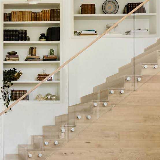 Standoff-mounted glass railing along a wood staircase